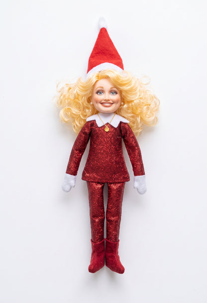 Red glitter Dolly Parton inspired Christmas elf doll on a clean white background.